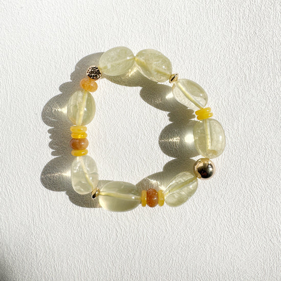 Beaded bracelet with yellow and orange accents on a white background