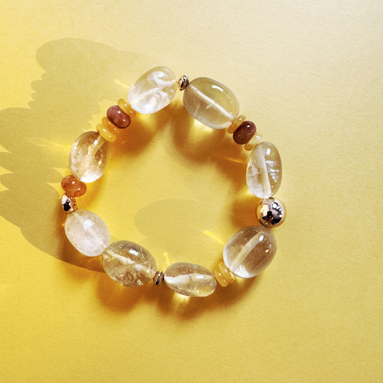 Bracelet with clear and brown beads on a yellow background